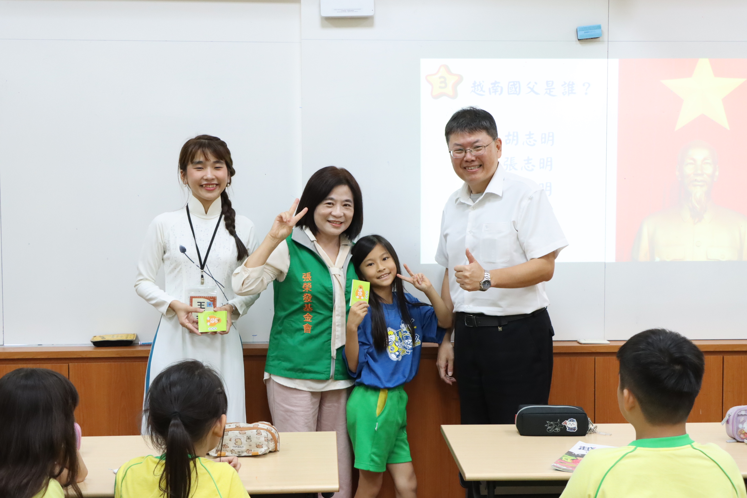 張榮發基金會執行長鍾德美(左二)至新北市成功國小與校長蔡建文 (右一)、新二代多元文化種子講師王靜宜(左一)及學生一同合影。