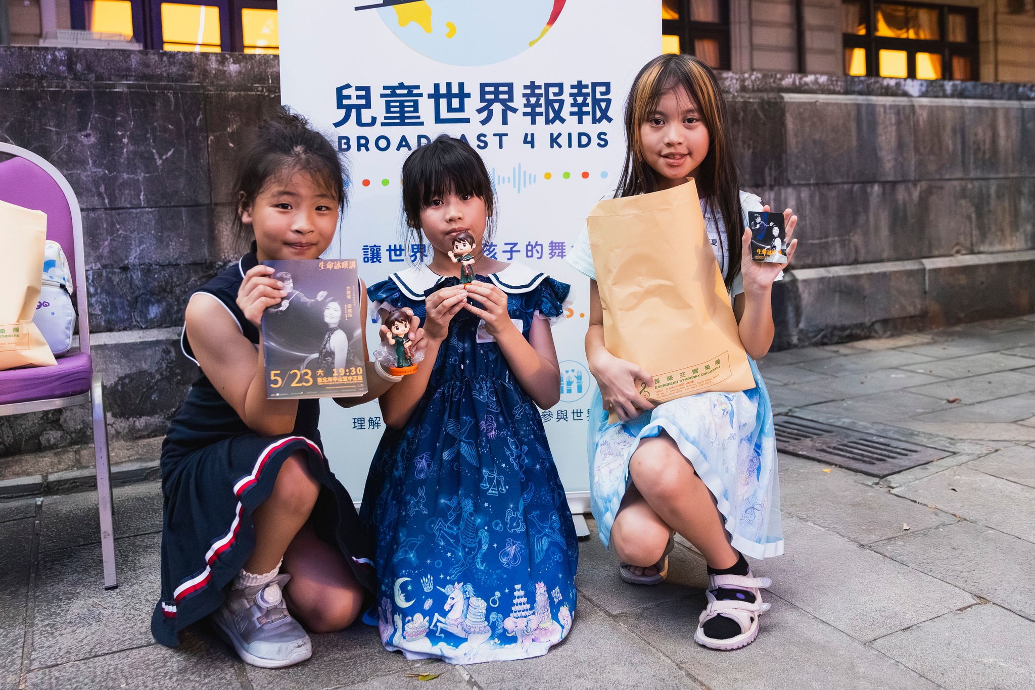 參與活動的孩子們手拿演出節目冊、小卡與樂團紀念公仔，留下美好回憶。