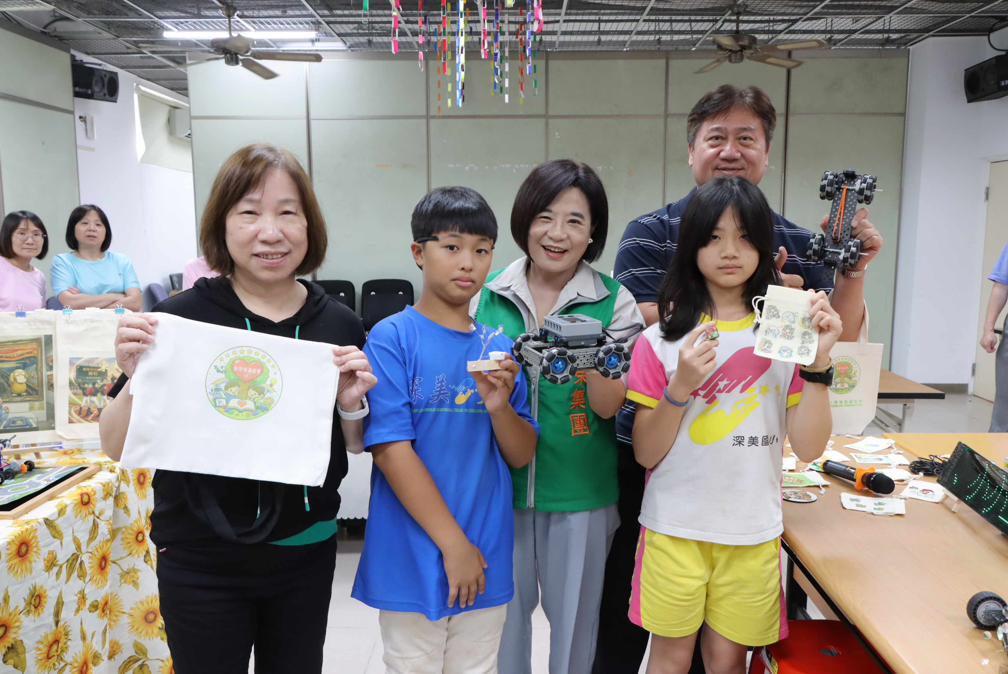 張榮發基金會執行長鍾德美(右二)、基隆市教育處課程教學科課程督學巫建男(後)、深美國小校長楊金芳(左一)，與學生在創客作品前合影。