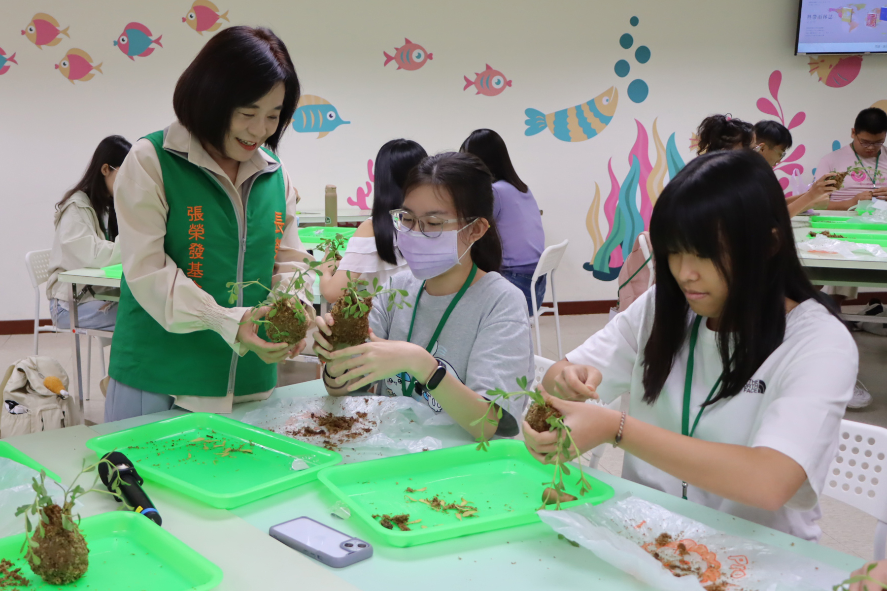 張榮發基金會執行長鍾德美(左一)與環保營學員共同參與植物苔球DIY活動。