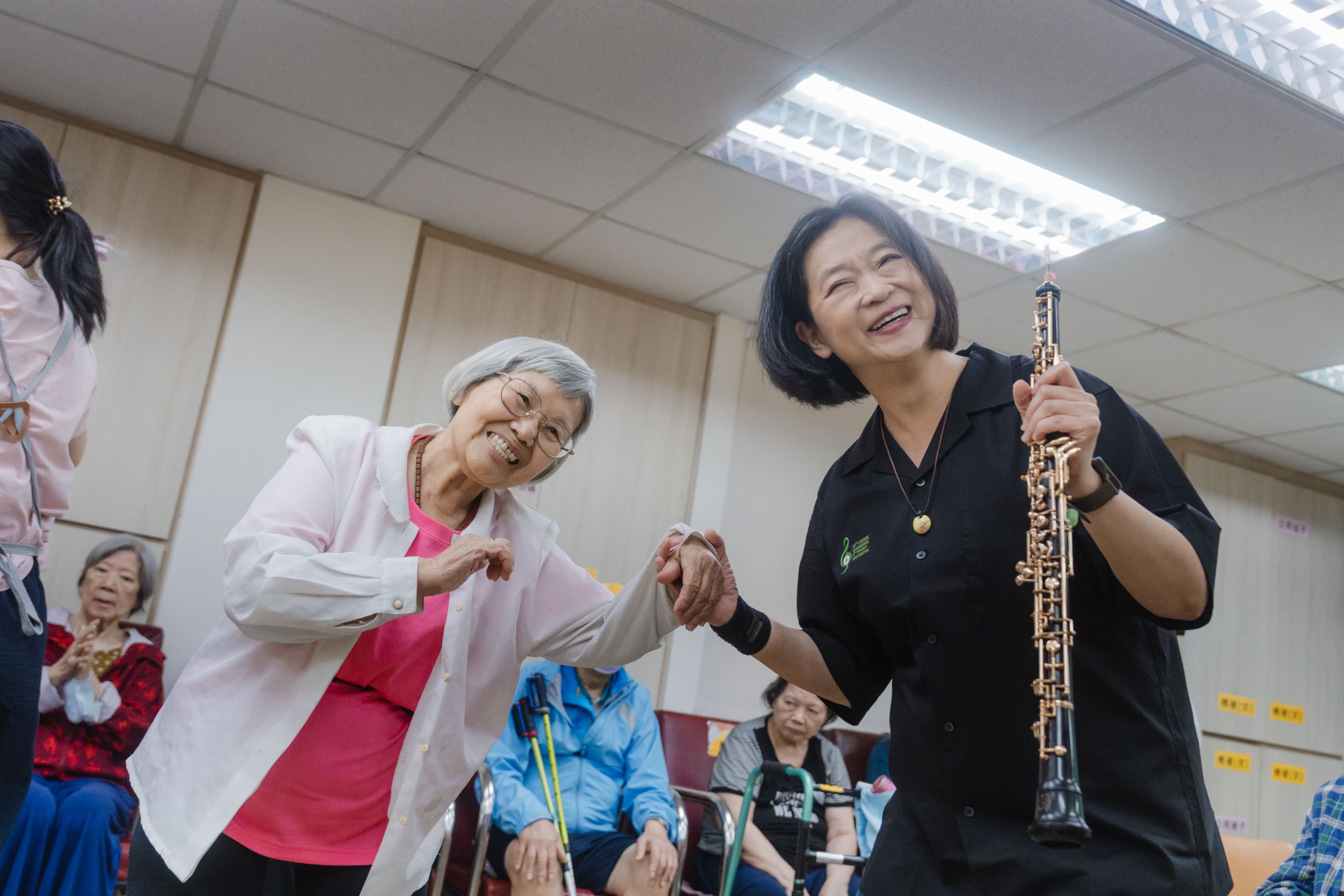 長者欣賞長榮交響樂團帶來的義演演出，並與團員在節奏互動中感受音樂樂趣。